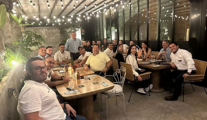 Cala Roca Un grupo de personas sentadas alrededor de una mesa en un restaurante, disfrutando de una comida juntos.