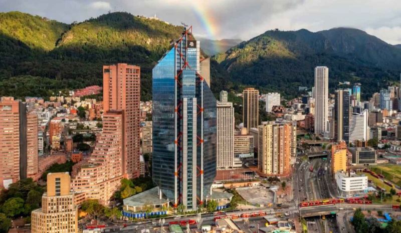 A rainbow stretches over Bogotá, illuminating the sky with its vibrant colors.