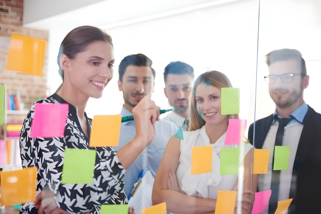 Equipo creativo realizando una sesión de brainstorming sobre cristal para la planificación de campañas publicitarias de hoteles en 2026.