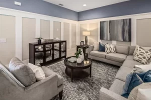 Sala de estar con paredes azules y molduras blancas, creando un ambiente acogedor y moderno.