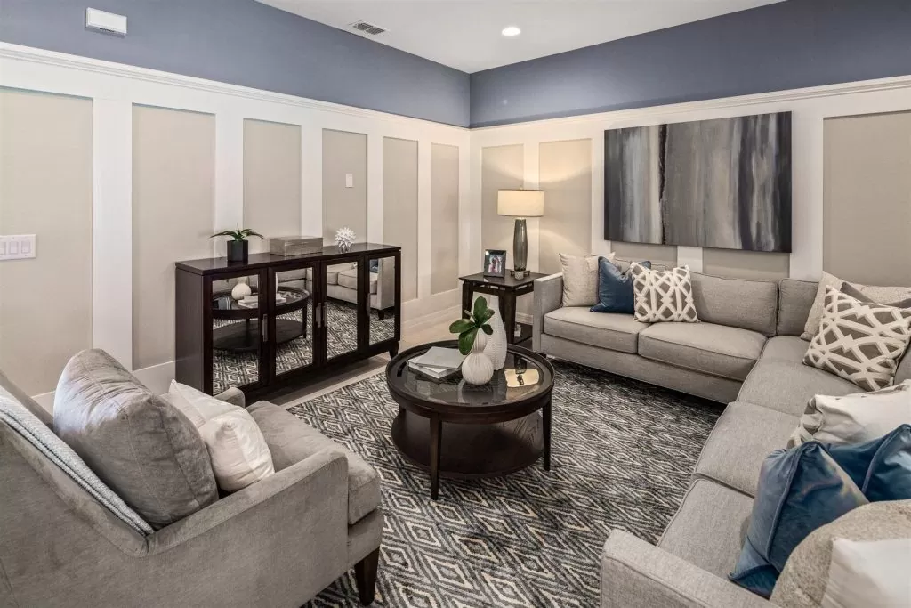 Sala de estar con paredes azules y molduras blancas, creando un ambiente acogedor y moderno.