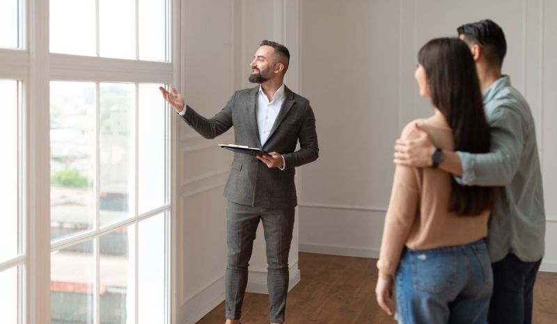 Realtor presentando apartamento en venta para una pareja