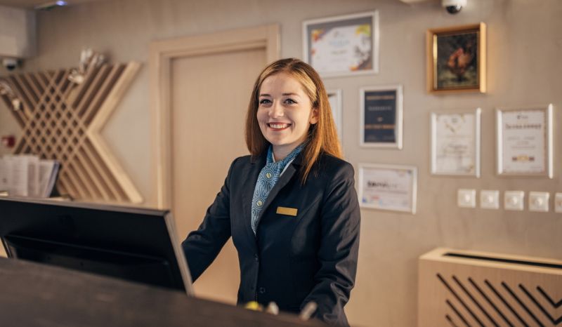 Hotel receptionist hosting guests who already made their reservation through a search engine