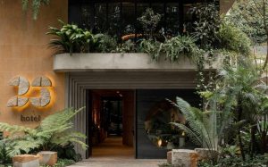 Entrada del 23 Hotel, rodeada de plantas y árboles, que evoca lujo y experiencias tropicales en El Poblado