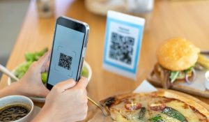 Persona capturando un código QR para obtener el menú del restaurante.
