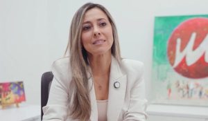 Mujer con blazer blanco sentada en un escritorio, representando a Patricia Raigoza, Gerente Comercial de Milenio PC