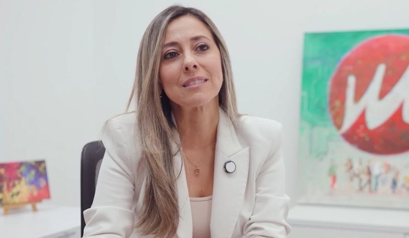 Mujer con blazer blanco sentada en un escritorio, representando a Patricia Raigoza, Gerente Comercial de Milenio PC
