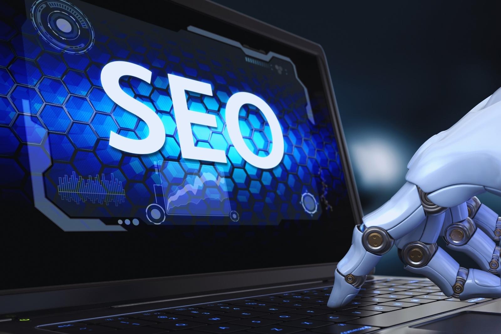Imagen de una mano robótica sobre un laptop, ilustrando la intersección entre tecnología y estrategias de SEO.