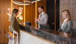 A man and a woman are standing in front of the reception desk.