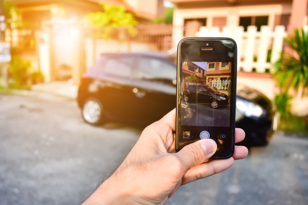 Persona sosteniendo un teléfono celular que muestra una imagen de un automóvil.