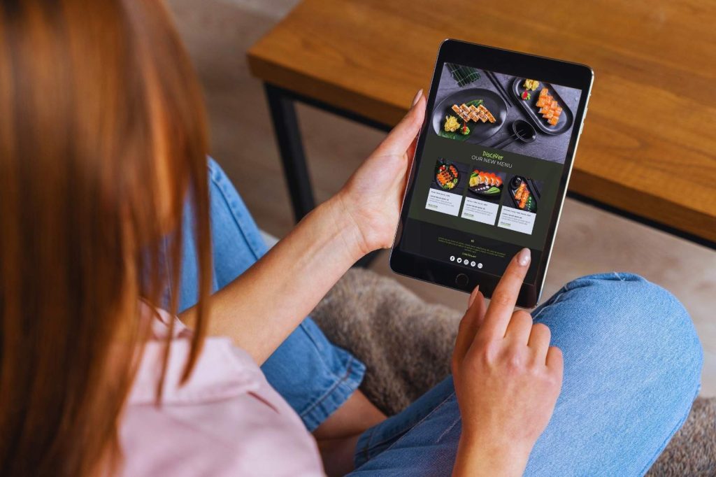A woman uses a tablet to place a food order.
