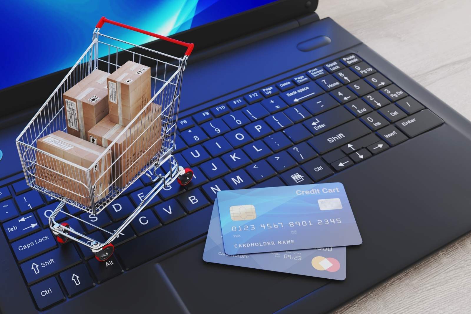 Carrito de compras y tarjeta de crédito sobre un laptop, simbolizando compras en línea.