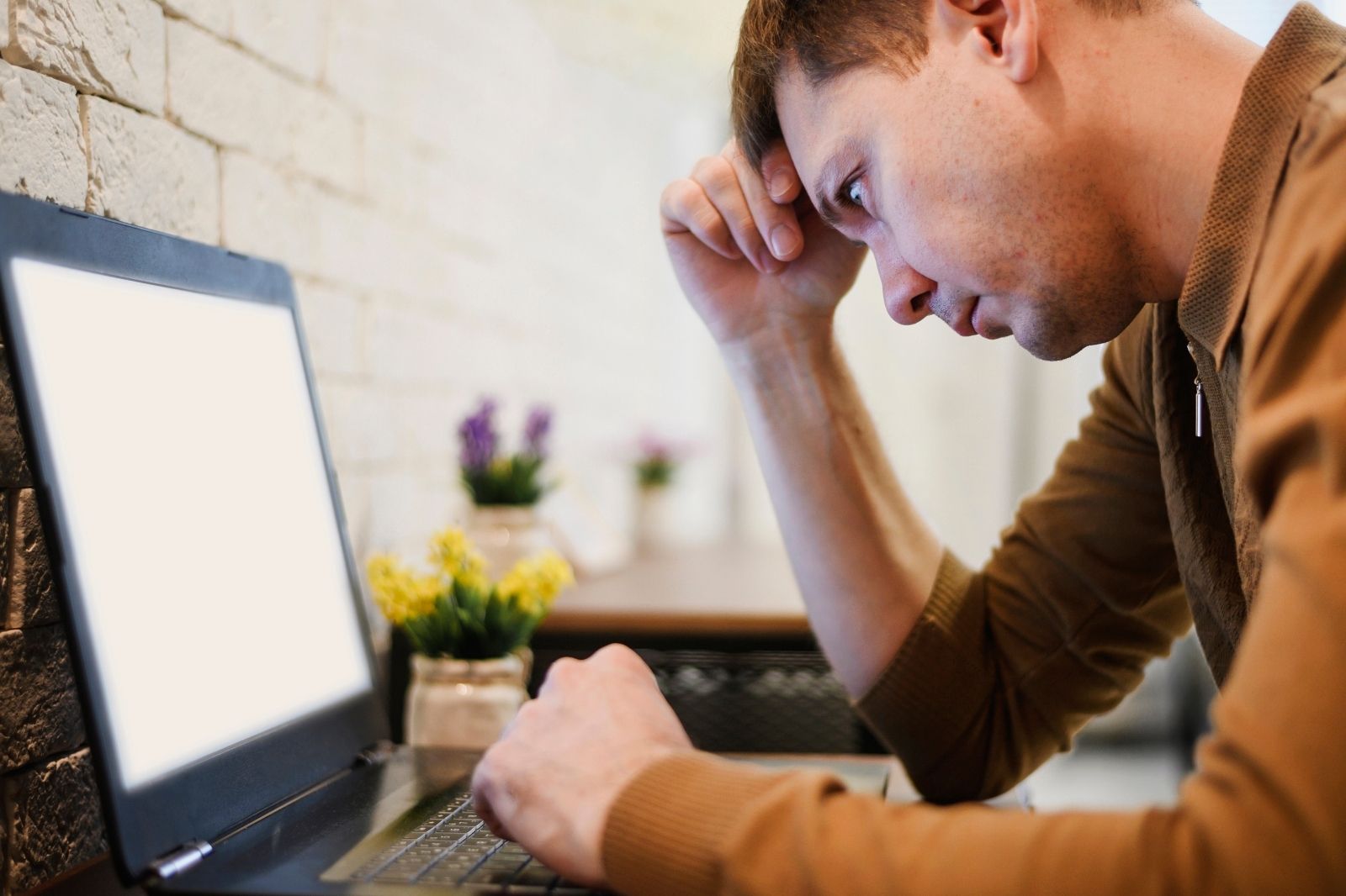 Un hombre observa atentamente la pantalla de su laptop.