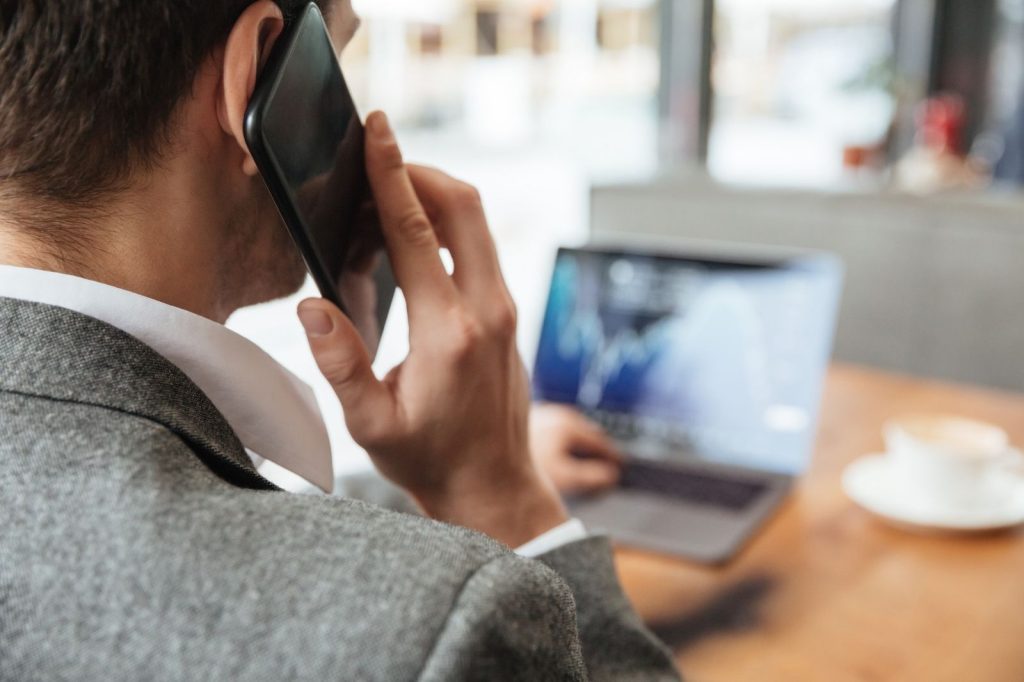 Un hombre vestido con traje habla por su teléfono celular.
