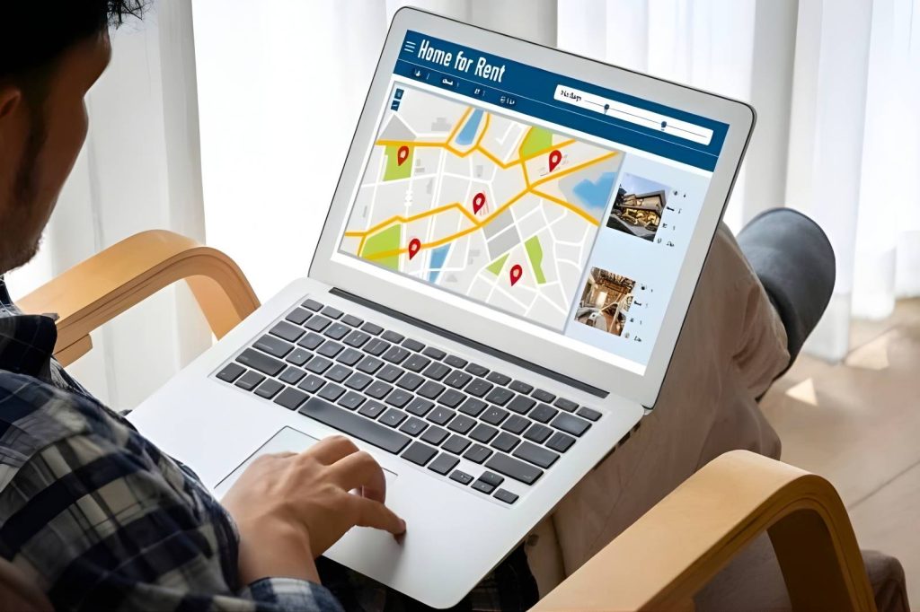 Un hombre consulta su laptop para encontrar opciones de hotel.