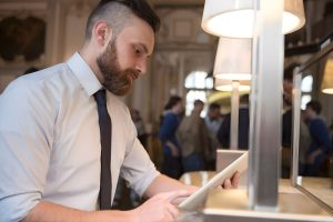 Un hombre con camisa y corbata utiliza una tableta.
