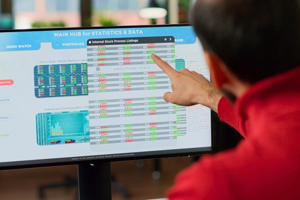 Un hombre señala una pantalla de computadora que muestra un gráfico.