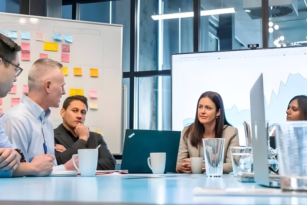 Un grupo de personas sentadas alrededor de una mesa en una sala de reuniones.