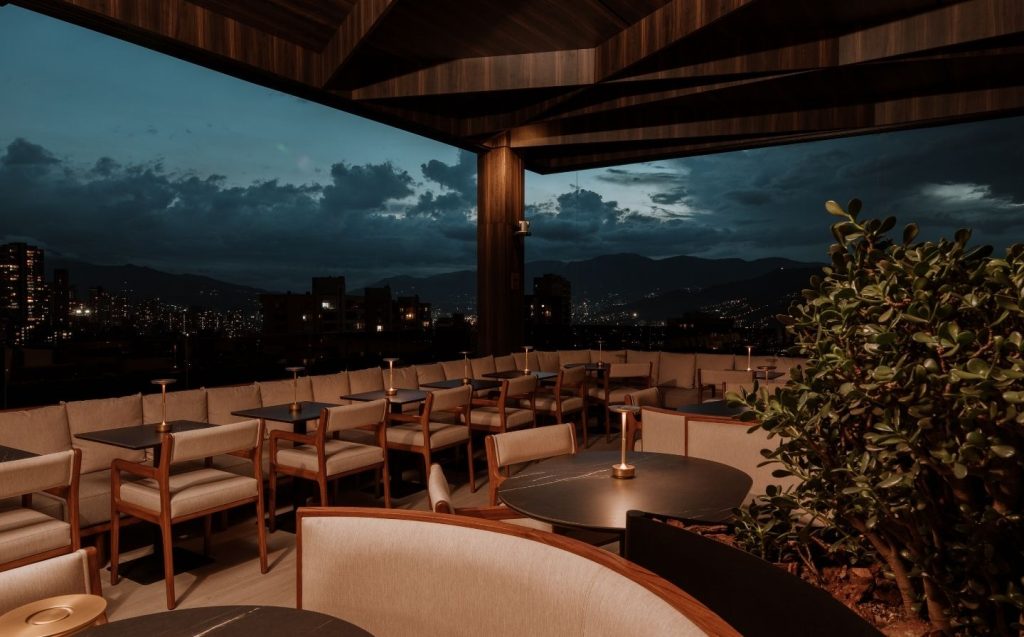 Terraza del hotel iluminada por la noche, destacando su ambiente acogedor en los mejores rooftops de Medellín 2026.
