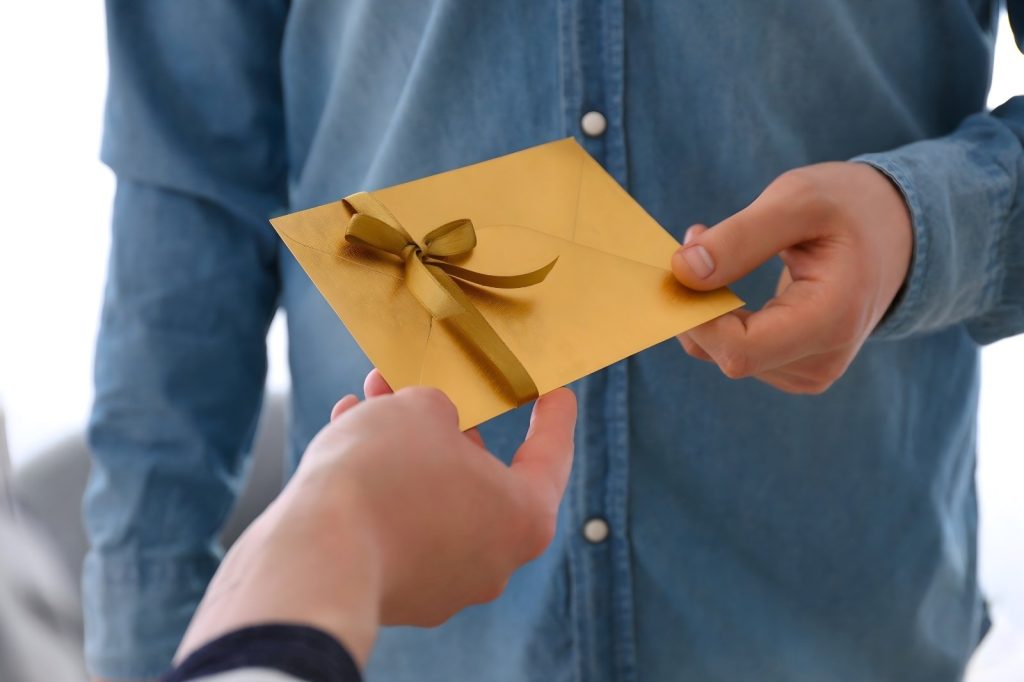 Un hombre está entregando un obsequio a otra persona.