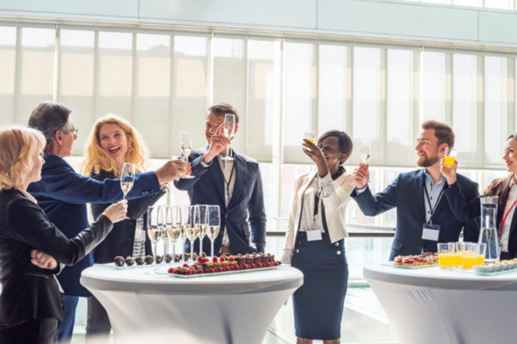 Personas de negocios levantando copas en un evento.