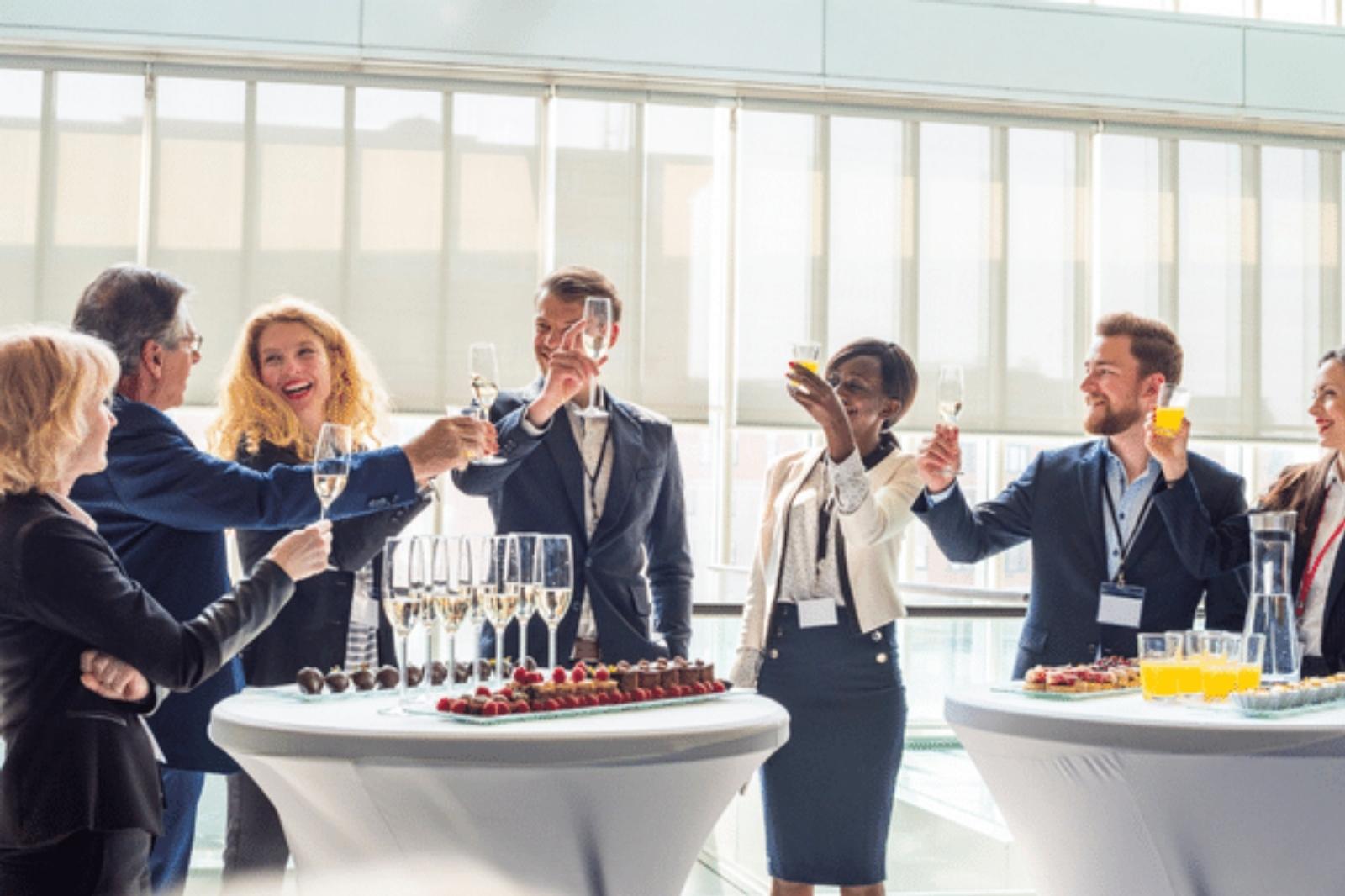 Personas de negocios levantando copas en un evento.