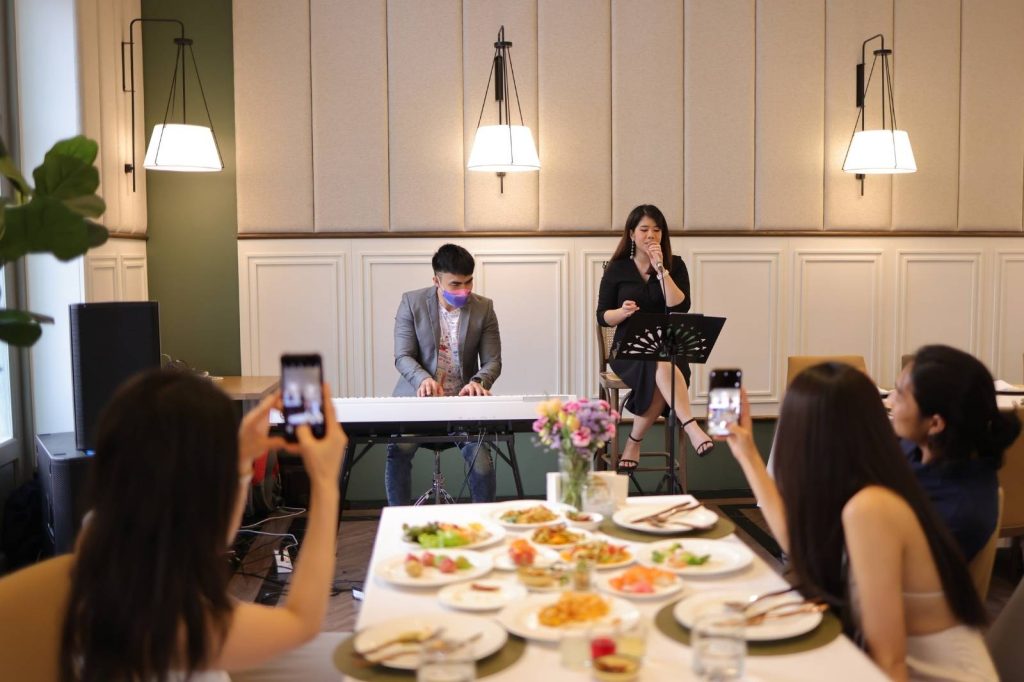 Varias personas compartiendo una comida en una mesa, rodeadas de platos.