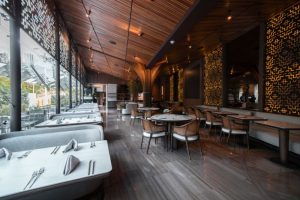 Espacio interior de un restaurante moderno, caracterizado por sus paredes de madera y un diseño minimalista.