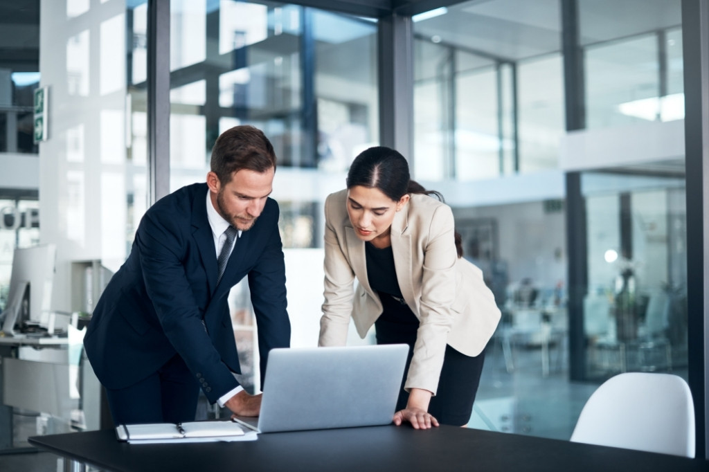 Equipo ejecutivo revisando estrategias digitales en una laptop para optimizar la presencia online de un hotel boutique.