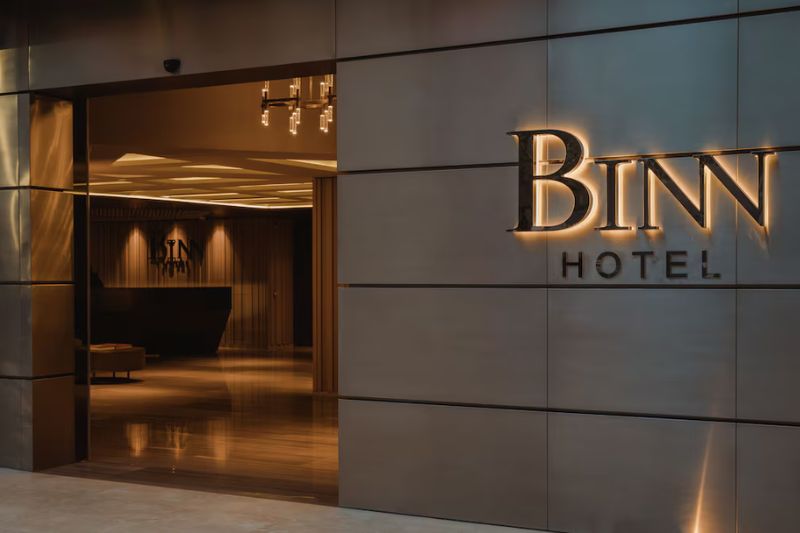 ntrada principal de lujo del Binn Hotel en Medellín con iluminación cálida y diseño moderno.