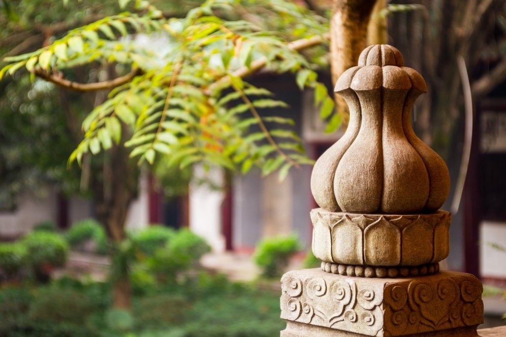Detalle de escultura decorativa en piedra en el jardín exterior de un hotel boutique de diseño.