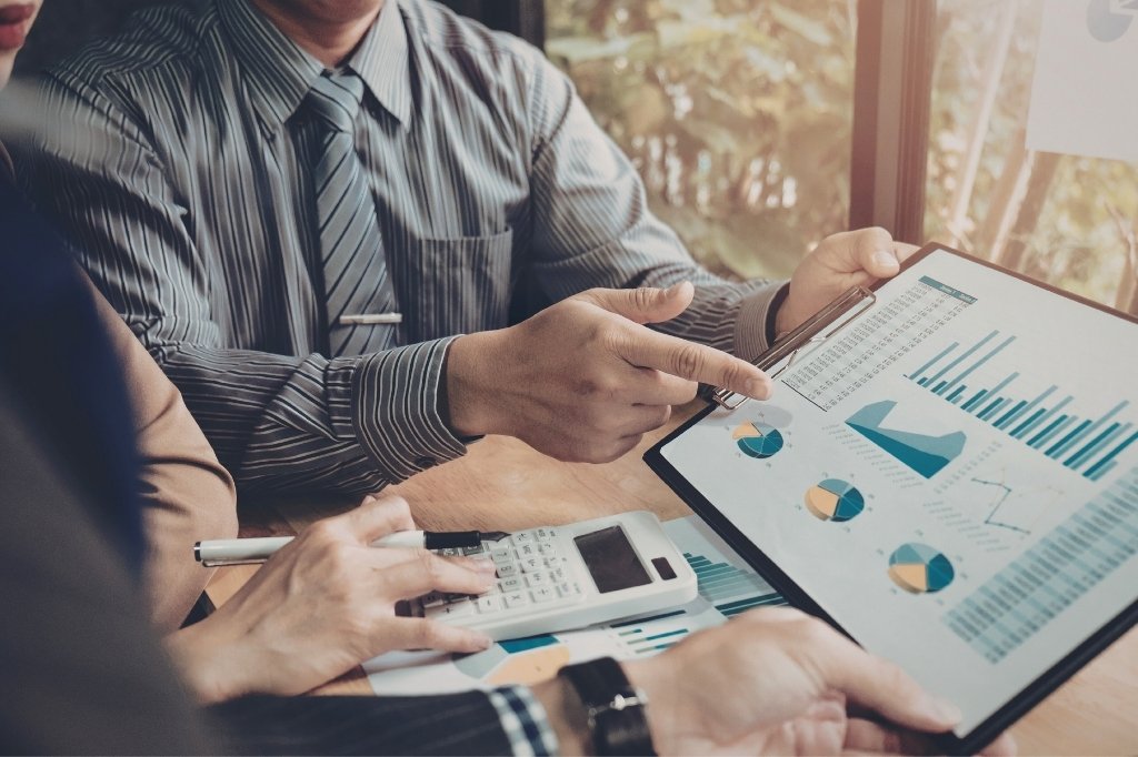 Análisis de métricas y gráficos en reunión, representando estrategias con IA para aumentar tráfico orgánico en restaurante.