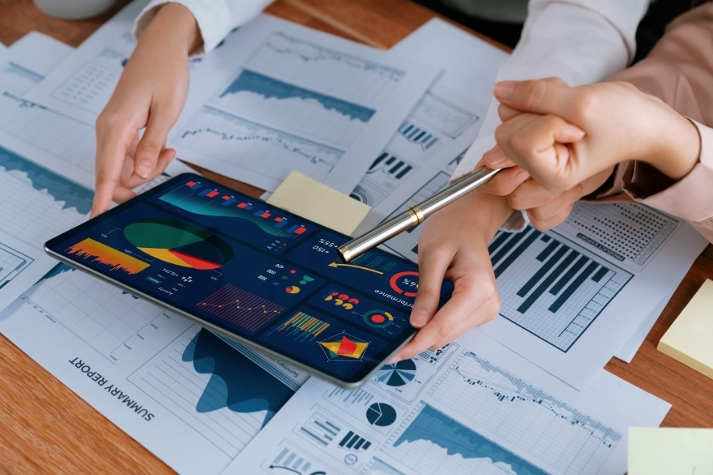 Análisis de datos en tablet con gráficos, representando uso de inteligencia artificial para predecir ocupación en hotel boutique.