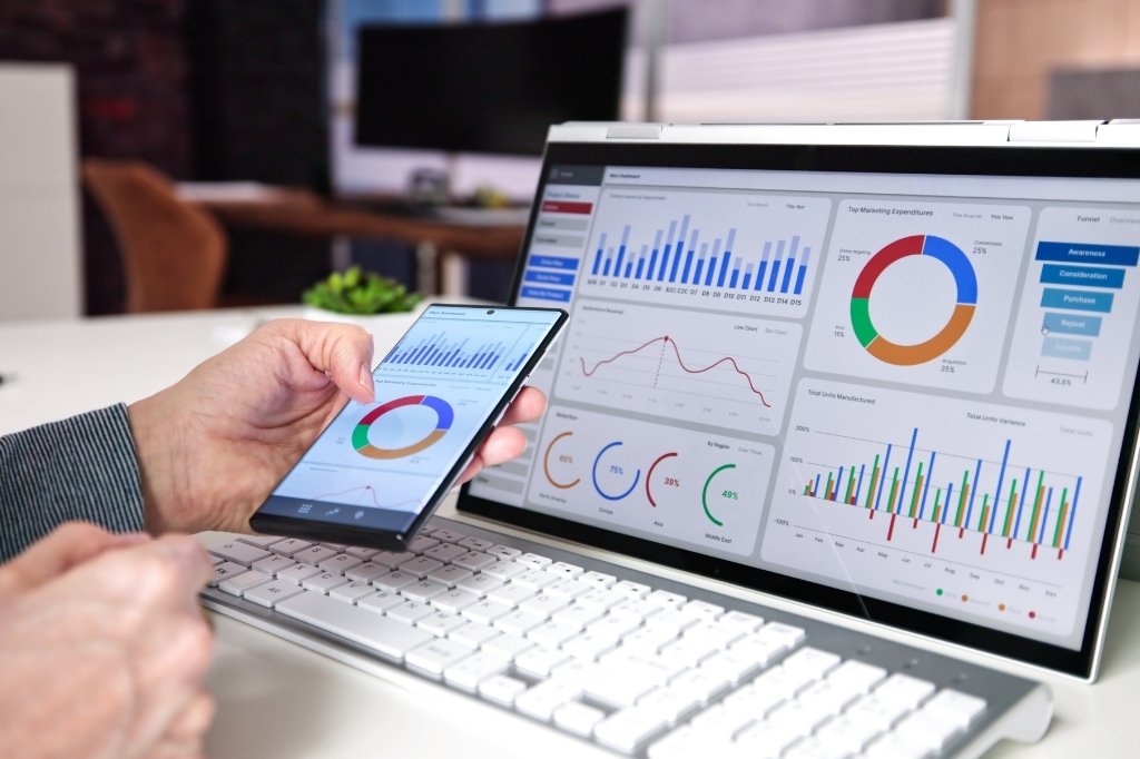 Panel de métricas y analítica digital en laptop y móvil, mostrando rendimiento y visibilidad online de hoteles en Google.
