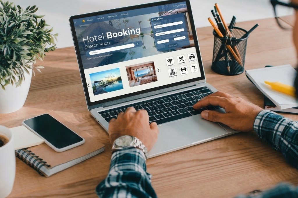 Usuario navegando en un sitio web de reservas de hotel en laptop, representando búsquedas y decisiones de último minuto.