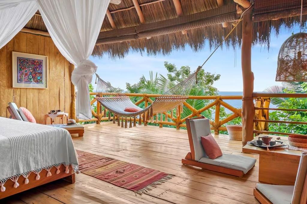 Hotel ecológico con diseño sostenible y vista natural, representando cómo la sostenibilidad certificada mejora el ranking en sistemas de IA.