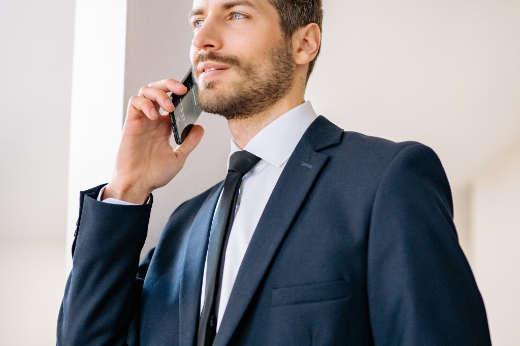Ejecutivo usando smartphone, representando la importancia de la velocidad de carga móvil en el SEO y reservas de hoteles.