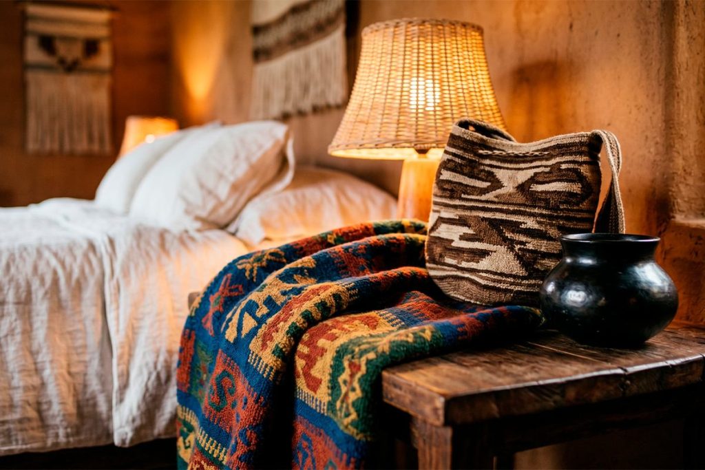 Habitación de lujo rústico con textiles artesanales, mochila Wayuu y elementos de diseño colombiano ancestral.