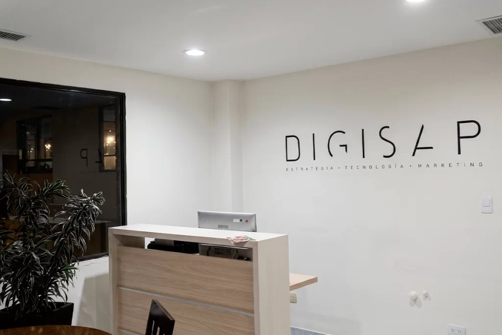 Recepción de las oficinas de Digisap en Bogotá con logotipo y tagline Estrategia + Tecnología + Marketing en la pared, sede de la agencia de marketing digital.